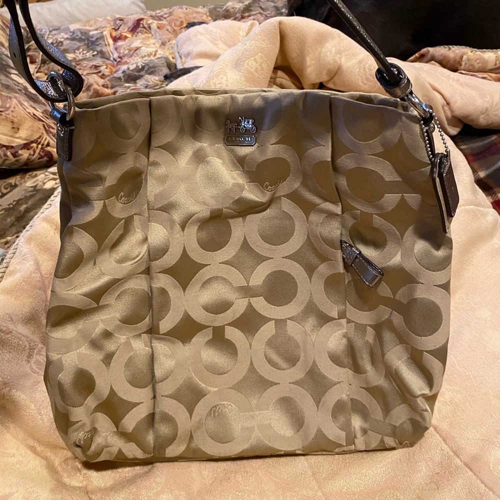 Coach Bucket Bag used once champagne w/maroon satin lining. Incl dust cover bag